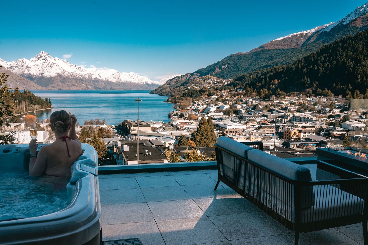 Panoramic view of Queenstown New Zealand with Lake Wakatipu and snow-capped mountains in the background.