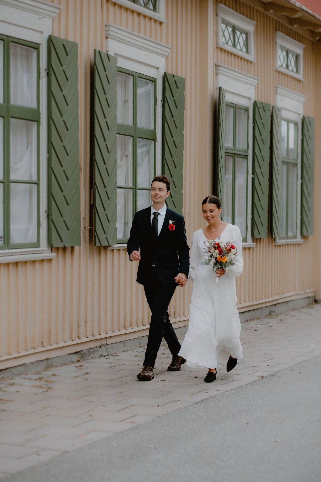 Bröllopsfotograf - par som kommer gående i gammalt kvarter