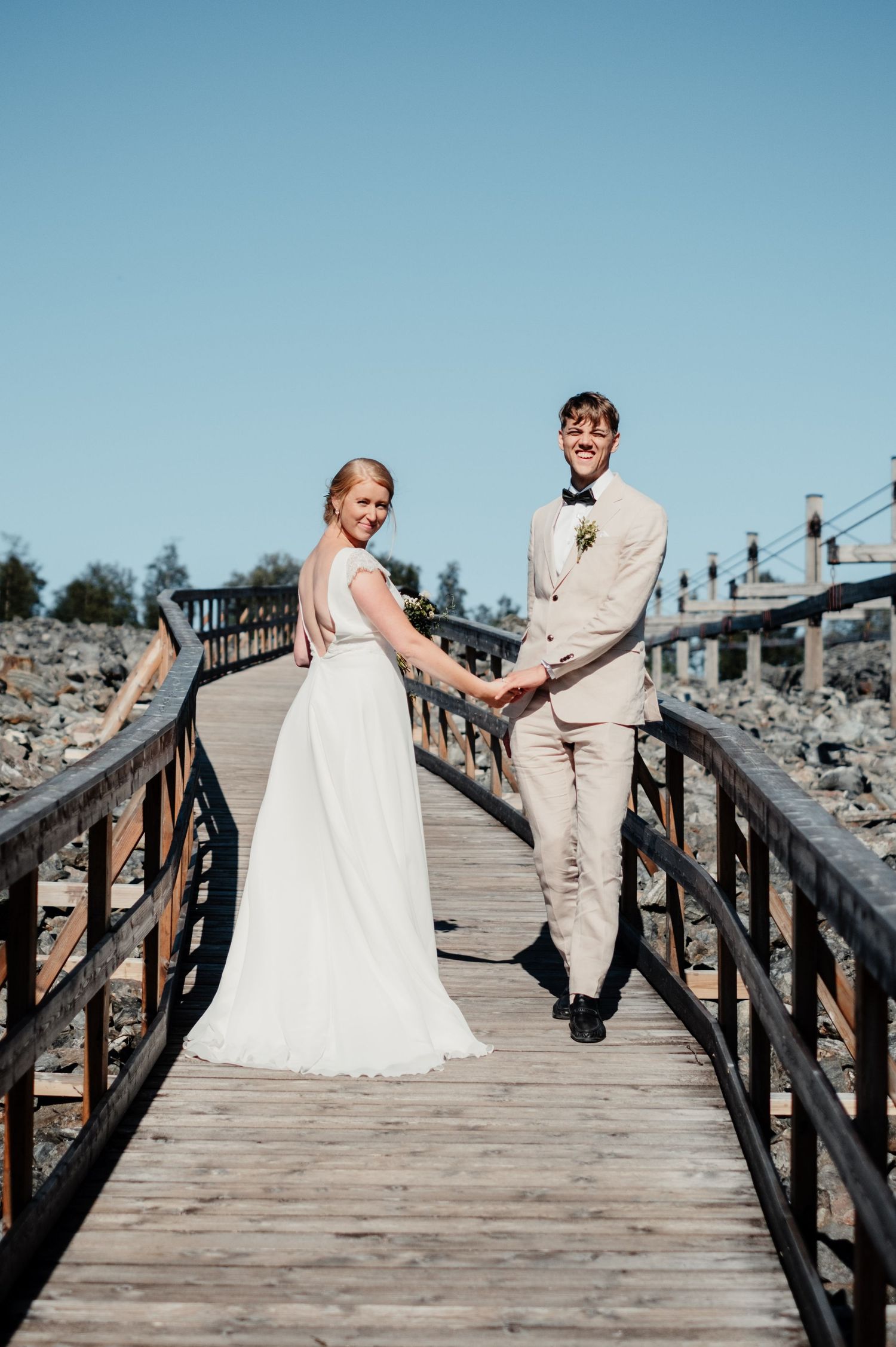 Bröllopsfotograf - par som är i fröå åre håller hand i solen