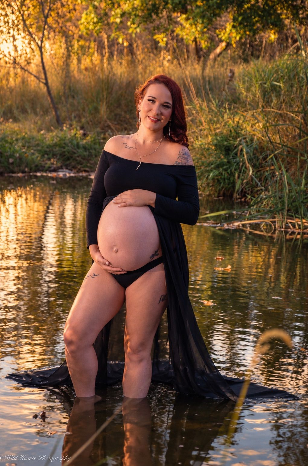 Angelina's maternity portrait
Expectant mother wearing a flowing black maternity gown while standing in a creek surrounded by golden autumn