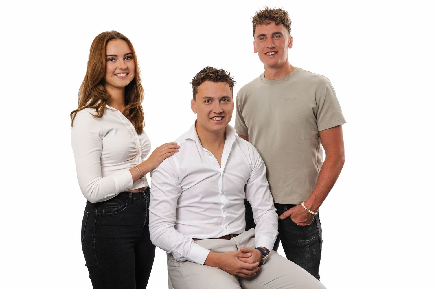 Three people in casual attire posing together against a white background in a professional studio setting.