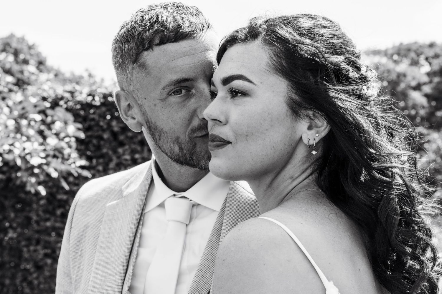 A romantic black and white photo sequence showing an intimate couple sharing tender moments outdoors.