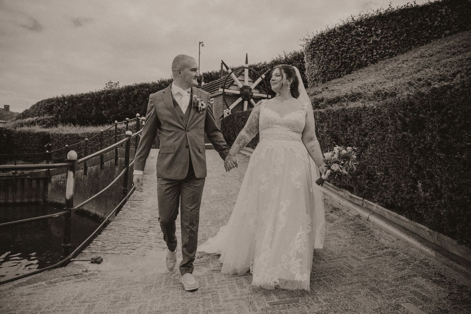 A series of black and white wedding photographs showing couples walking along a scenic outdoor path.