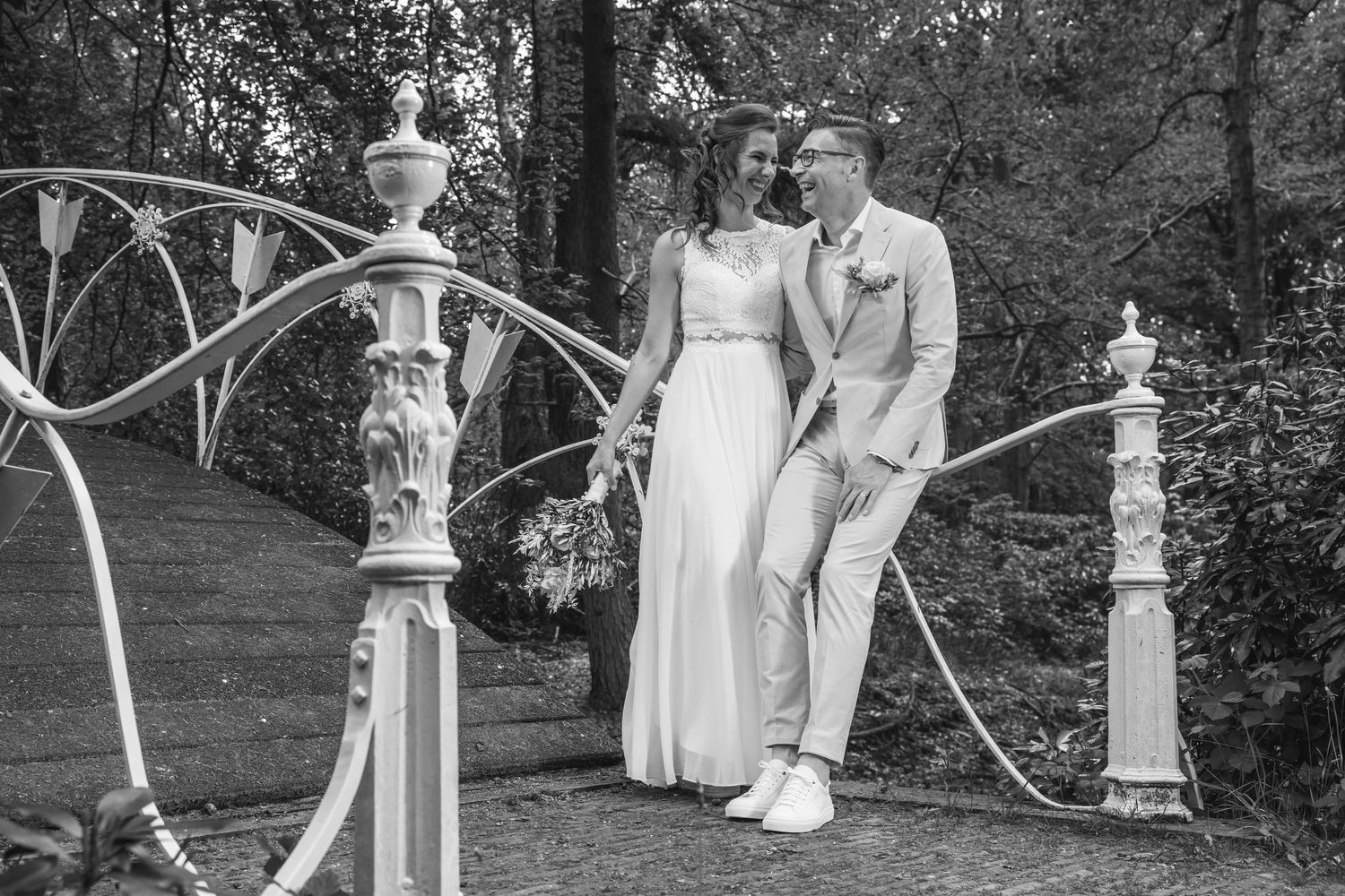 A black and white wedding photo collage featuring outdoor garden scenes with decorative stone pillars and formal attire.