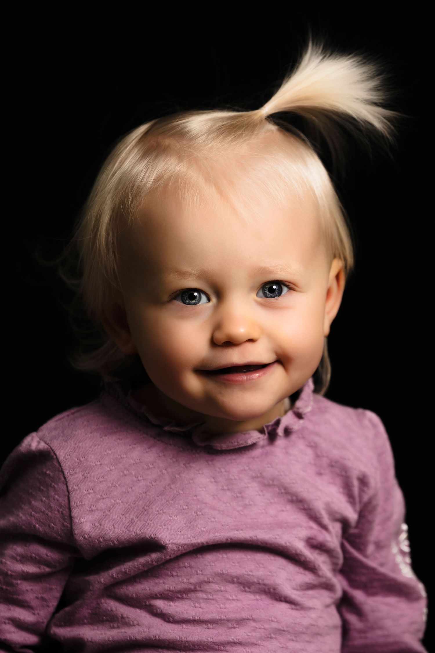 A series of five photos showing a baby in a purple sweater with different expressions and poses.