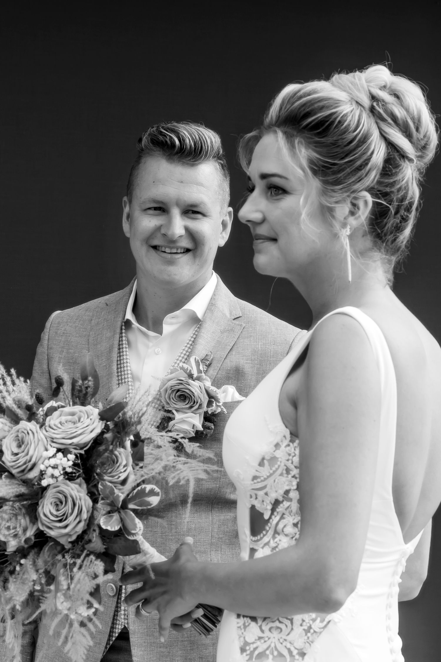 Black and white portrait of newlyweds with bridal bouquet.