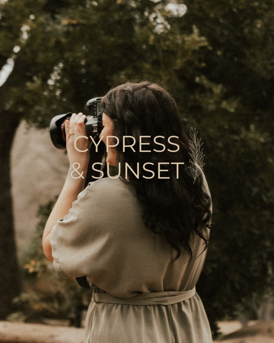 A photographer in a beige dress uses a professional camera to capture images in a natural outdoor setting.