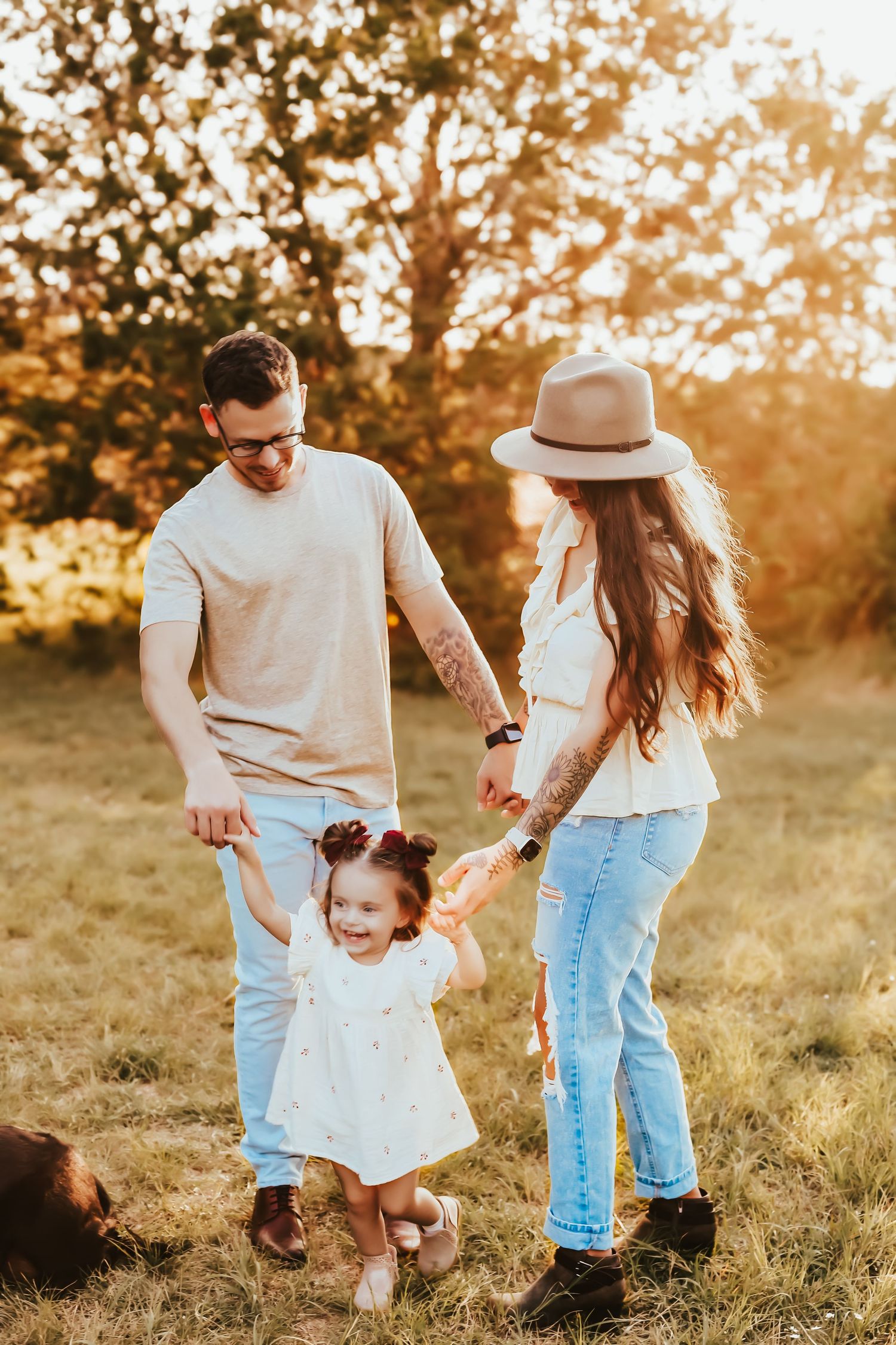 A family enjoys playful moments together in a sun-drenched field during golden hour.