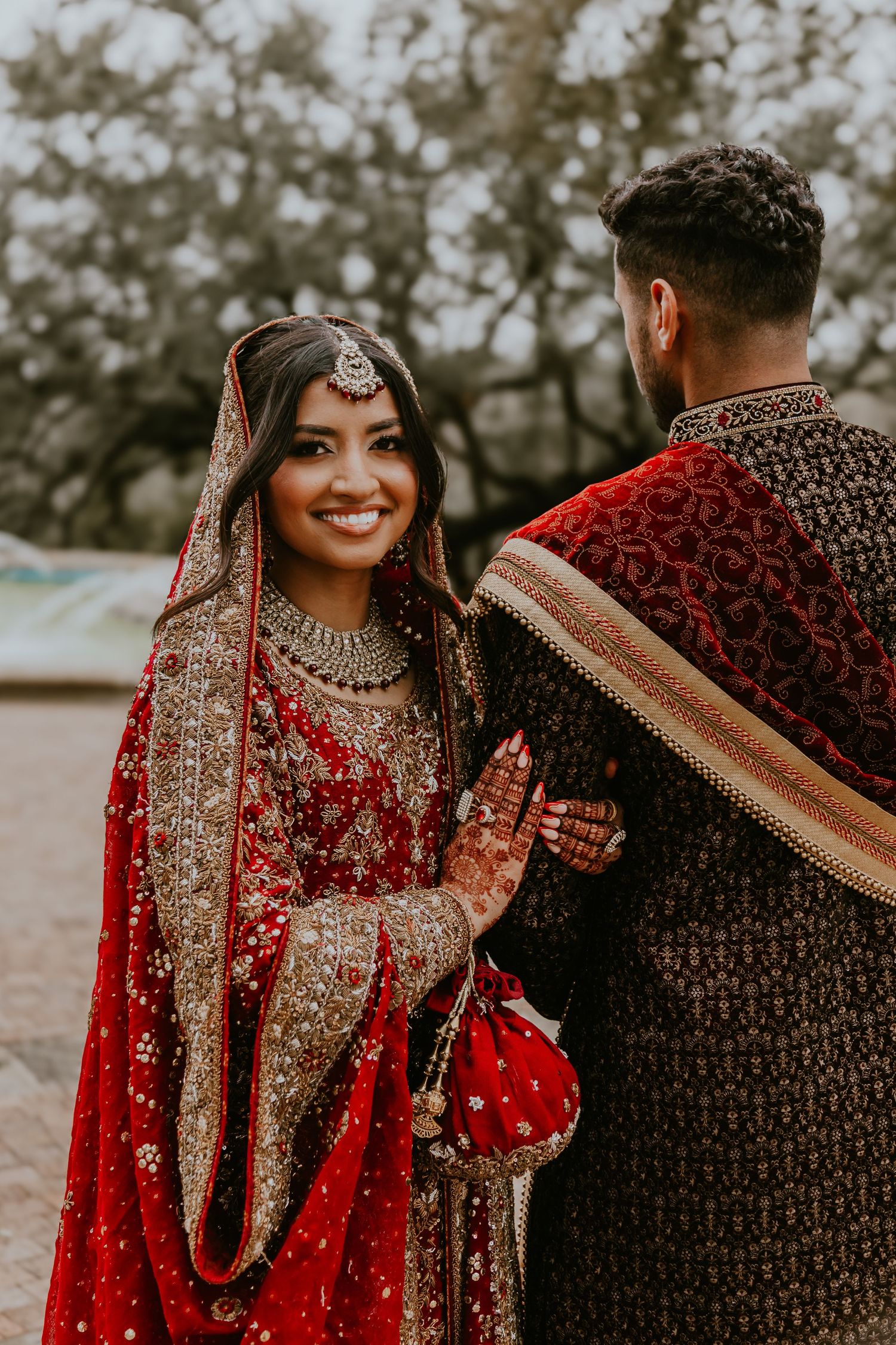 A series of romantic moments captured between a couple in traditional South Asian wedding attire with red and gold details.
