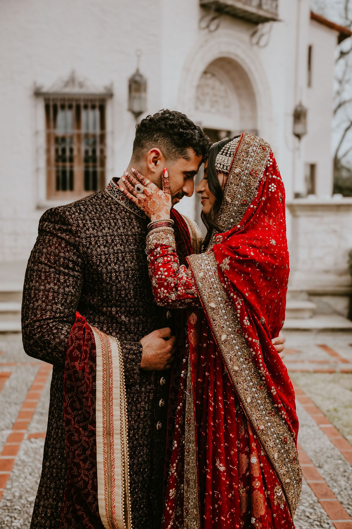 Couple embraces near architectural archways.