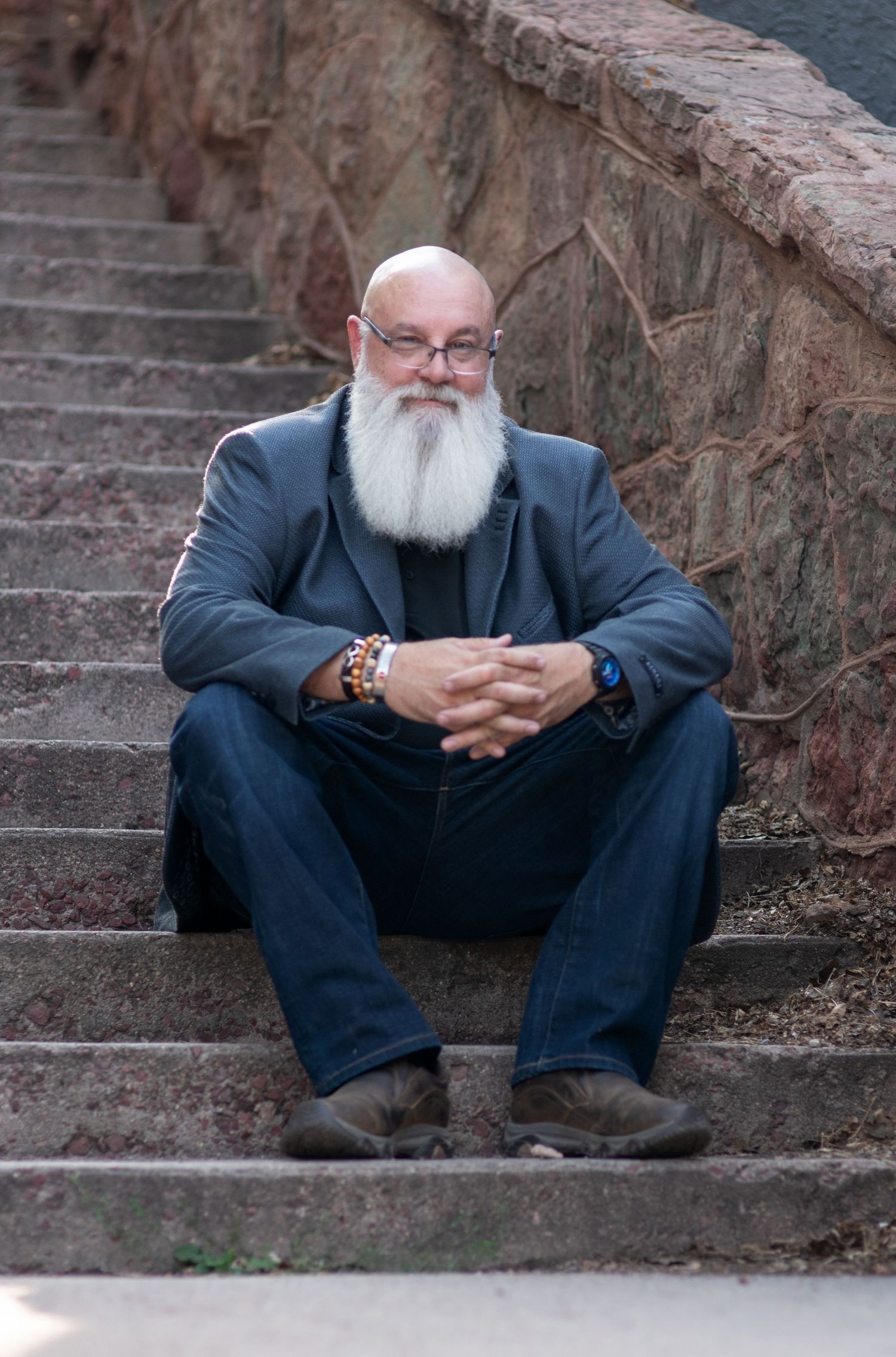 Close up portrait of man sitting on steps in Manitou Springs, CO. Photo by Elijah Grace Photo.