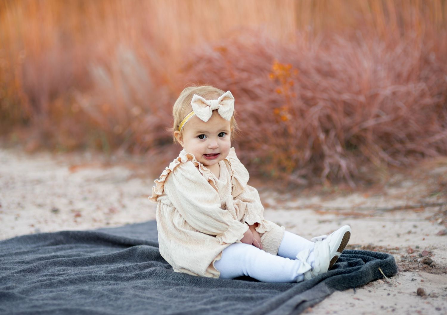toddler sitting on a blanket posing for photos
