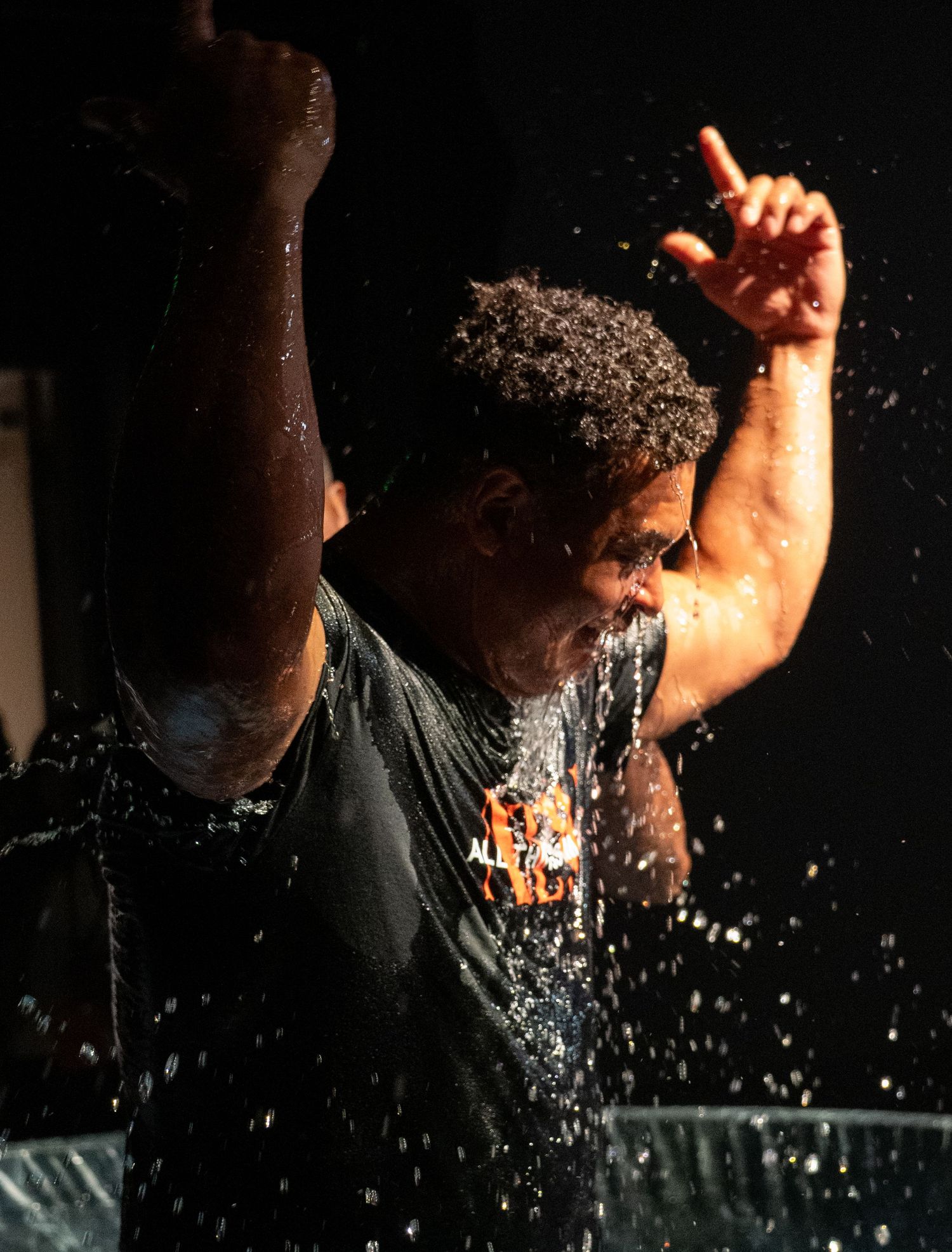 man celebrating arising from baptism waters at Zeal Church, Colorado Springs. Photo by Elijah Grace Photo