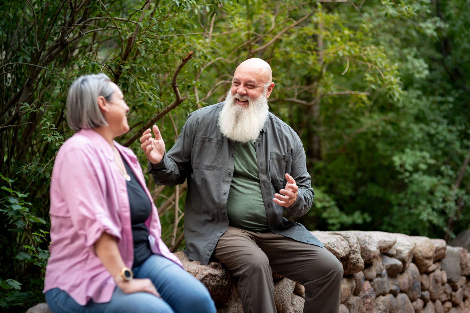Man and woman laughing sitting on a bridge at North Cheyenne Canyon, Colorado Springs. Photo by Elijah Grace Photo.