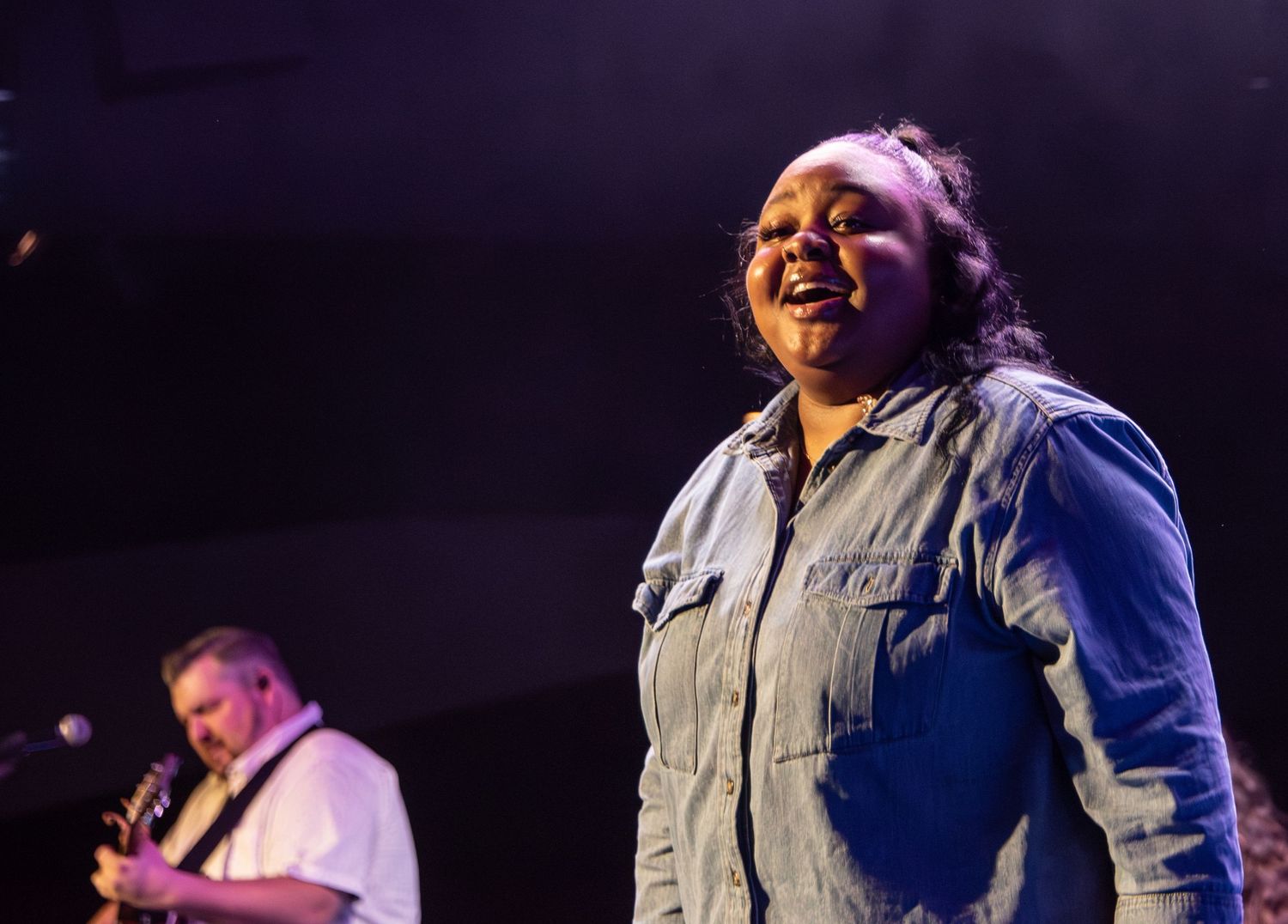 woman smiling worshiping with purple light at Zeal Church, Colorado Springs. Photo by Elijah Grace Photo