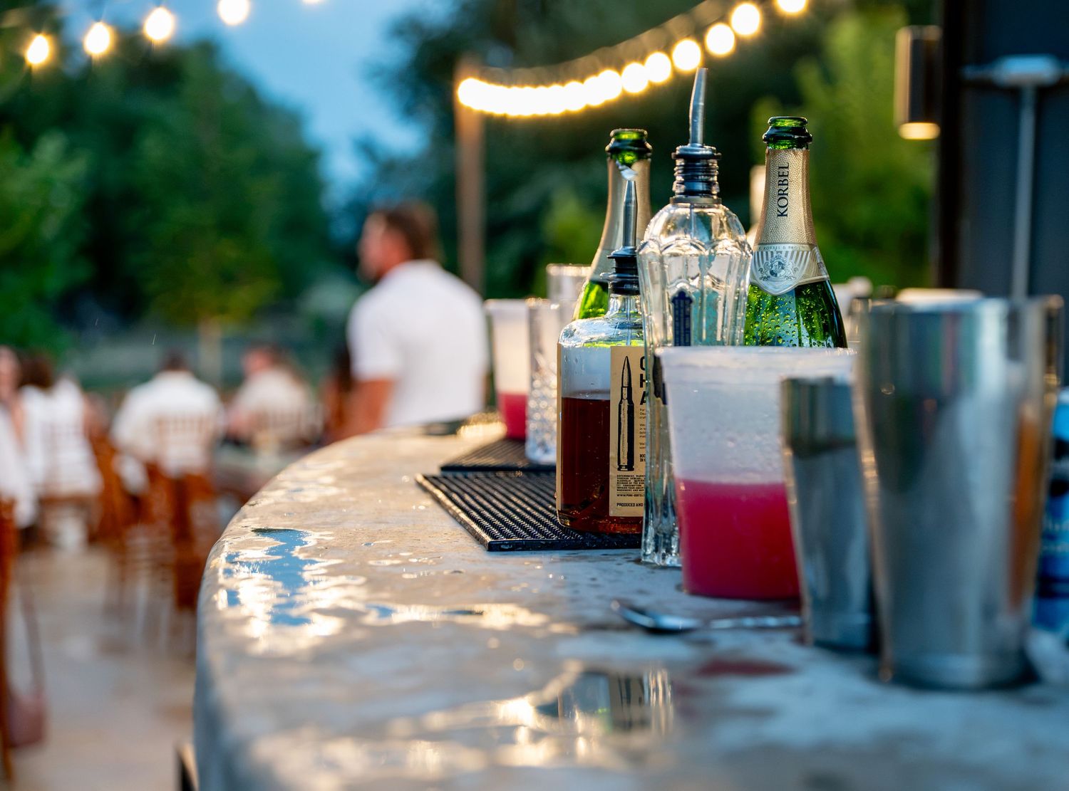 Bar with water reflection and outdoor event lights at Lazy Stud Ranch in Lyons, CO.