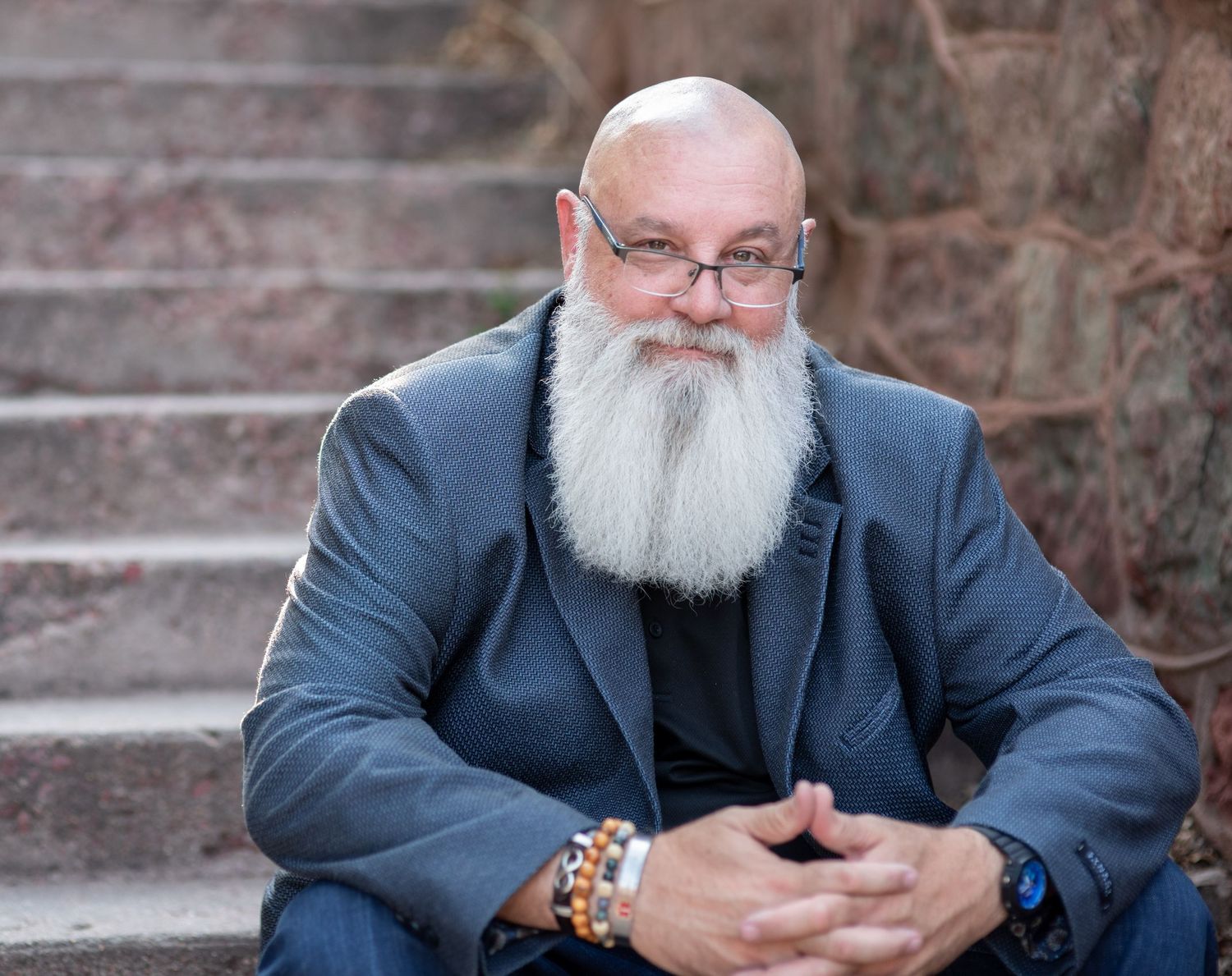 Close up portrait of man sitting on steps in Manitou Springs, CO. Photo by Elijah Grace Photo.