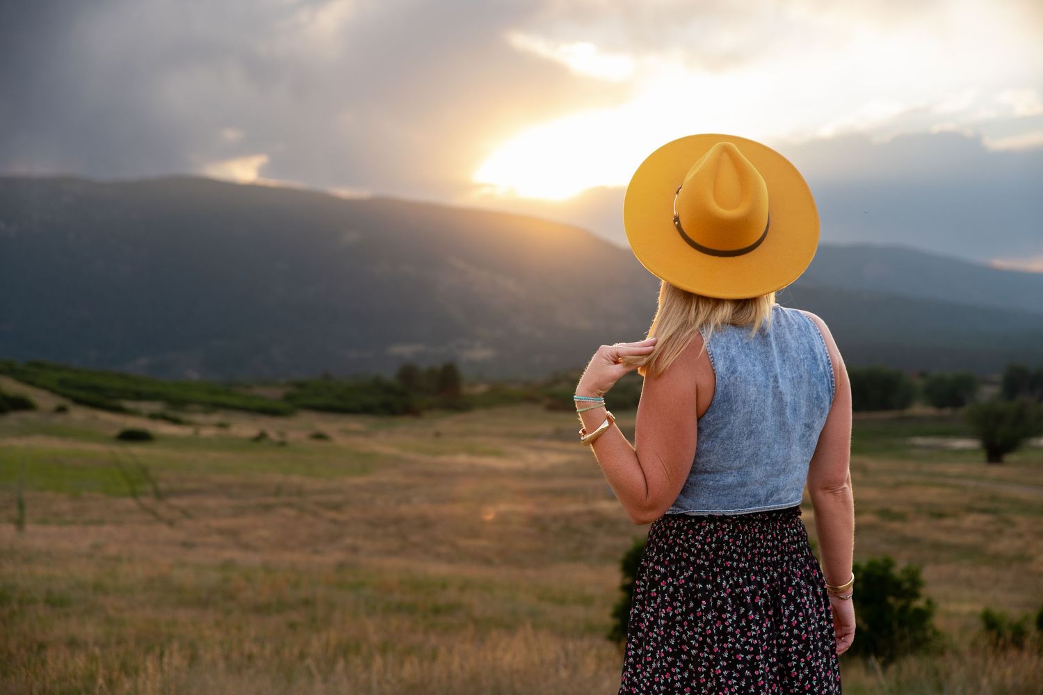 Photo of a woman watching the sunset at Sandstone Ranch open space in Larkspur, CO. Photo by Elijah Grace Photo.
