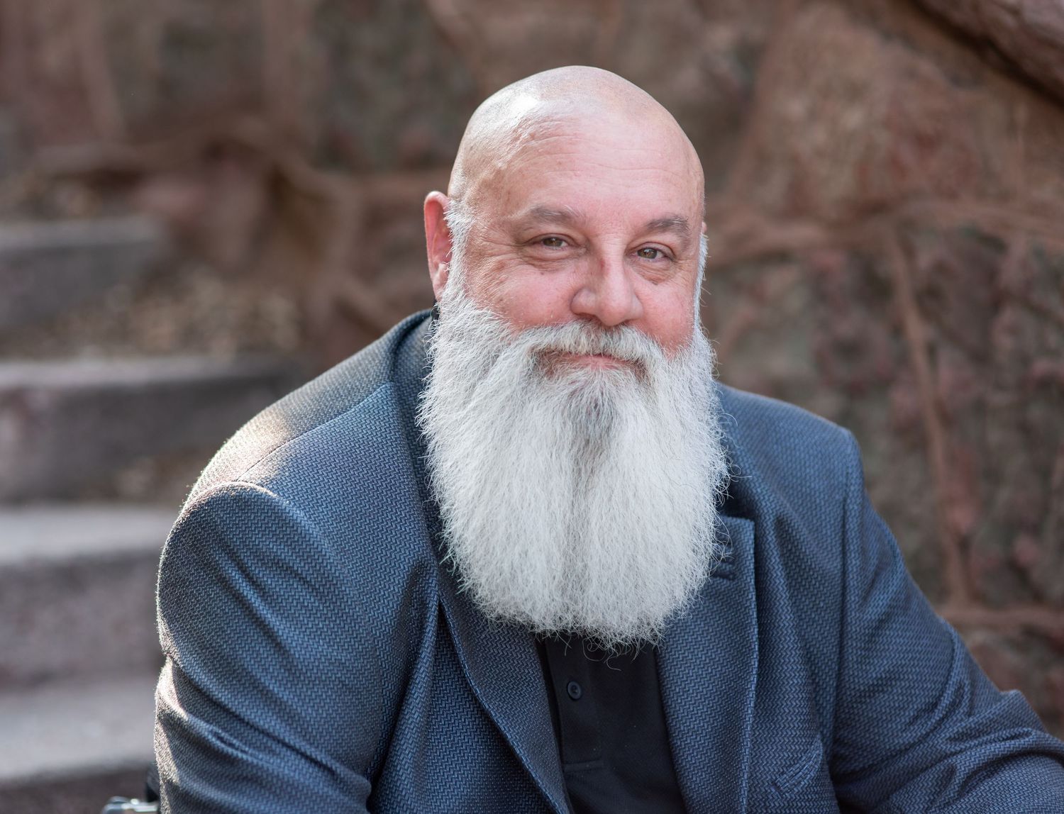Close up portrait of man sitting on steps in Manitou Springs, CO. Photo by Elijah Grace Photo.