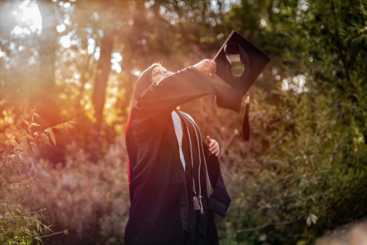 woman throwing graduation cap in the air