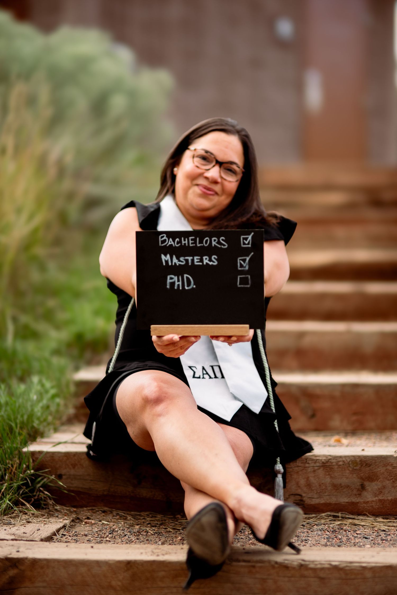 Woman Proudly showing off her graduation accomplishments at Red Rocks Park in Morrison, CO