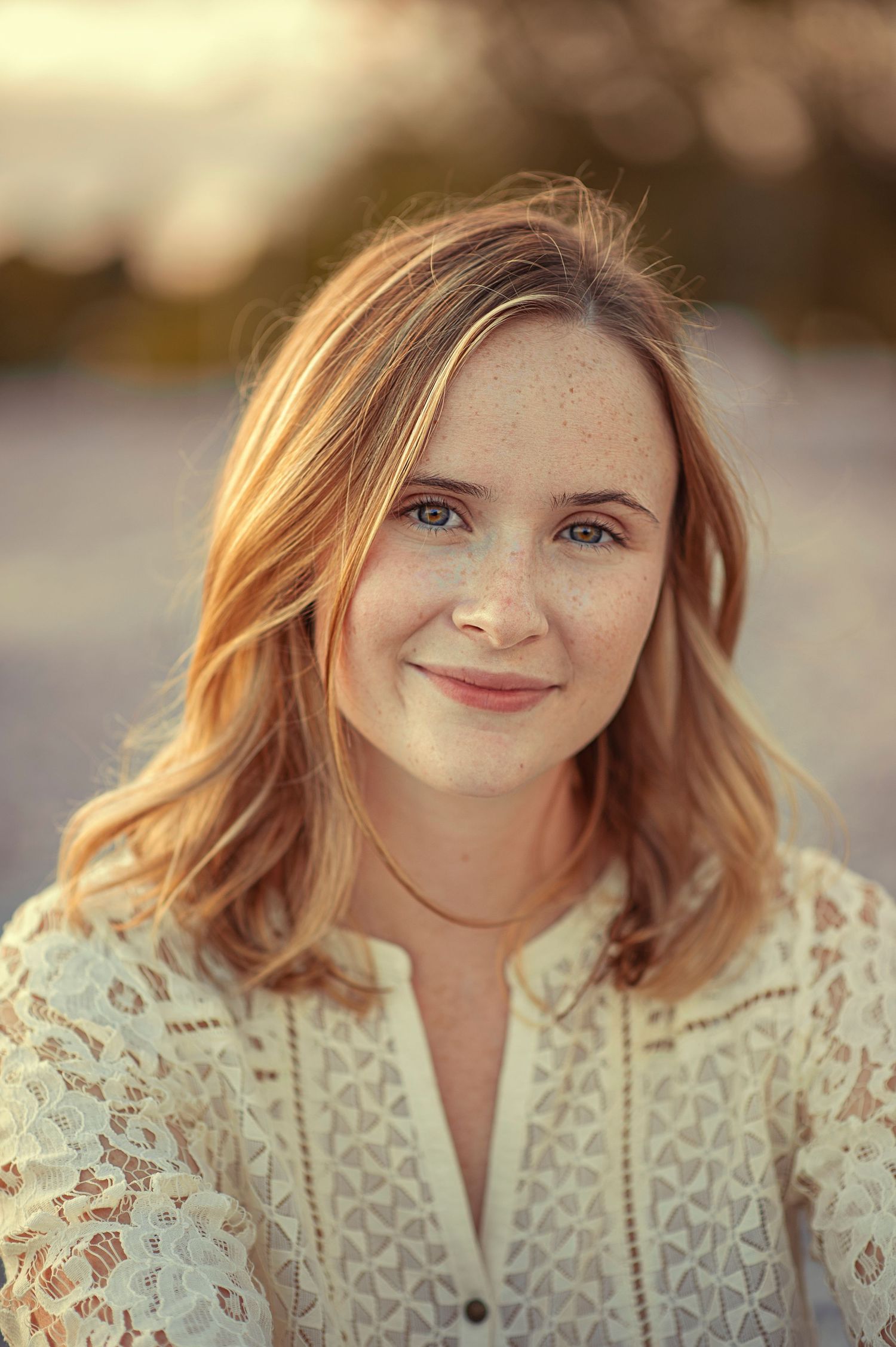 Portrait of person in white lace top with soft golden sunset lighting.