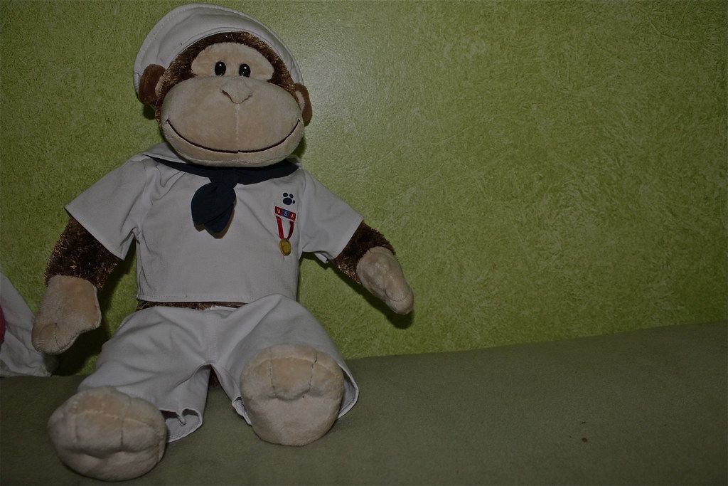Plush monkey toys wearing sailor outfits displayed on a green background.