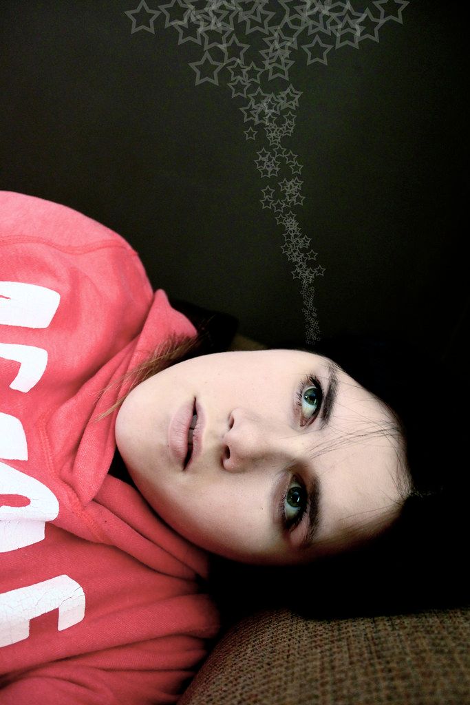A portrait with decorative star designs trailing above against a dark background.