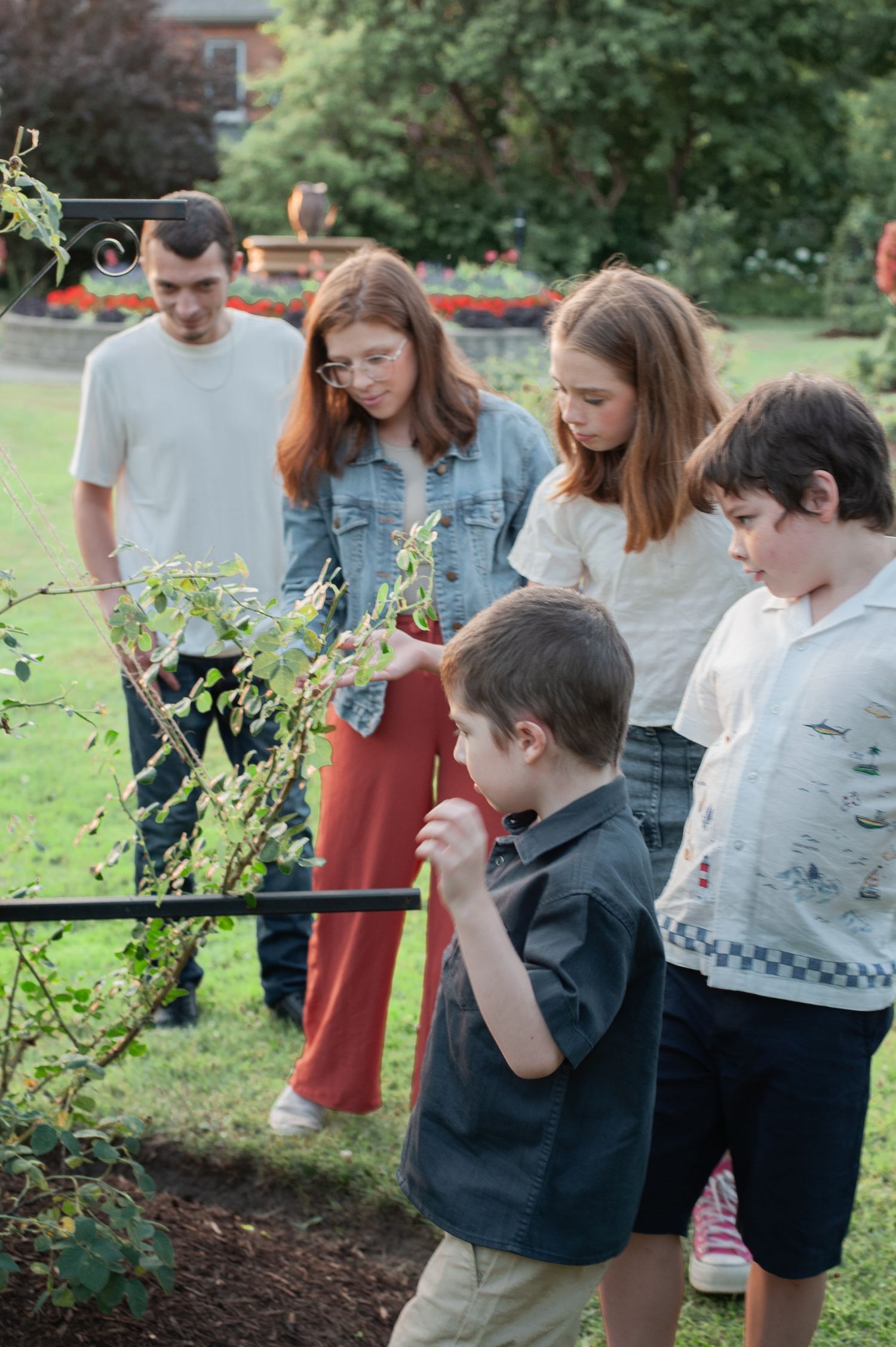 A group explores and observes plants together in a lush garden environment.