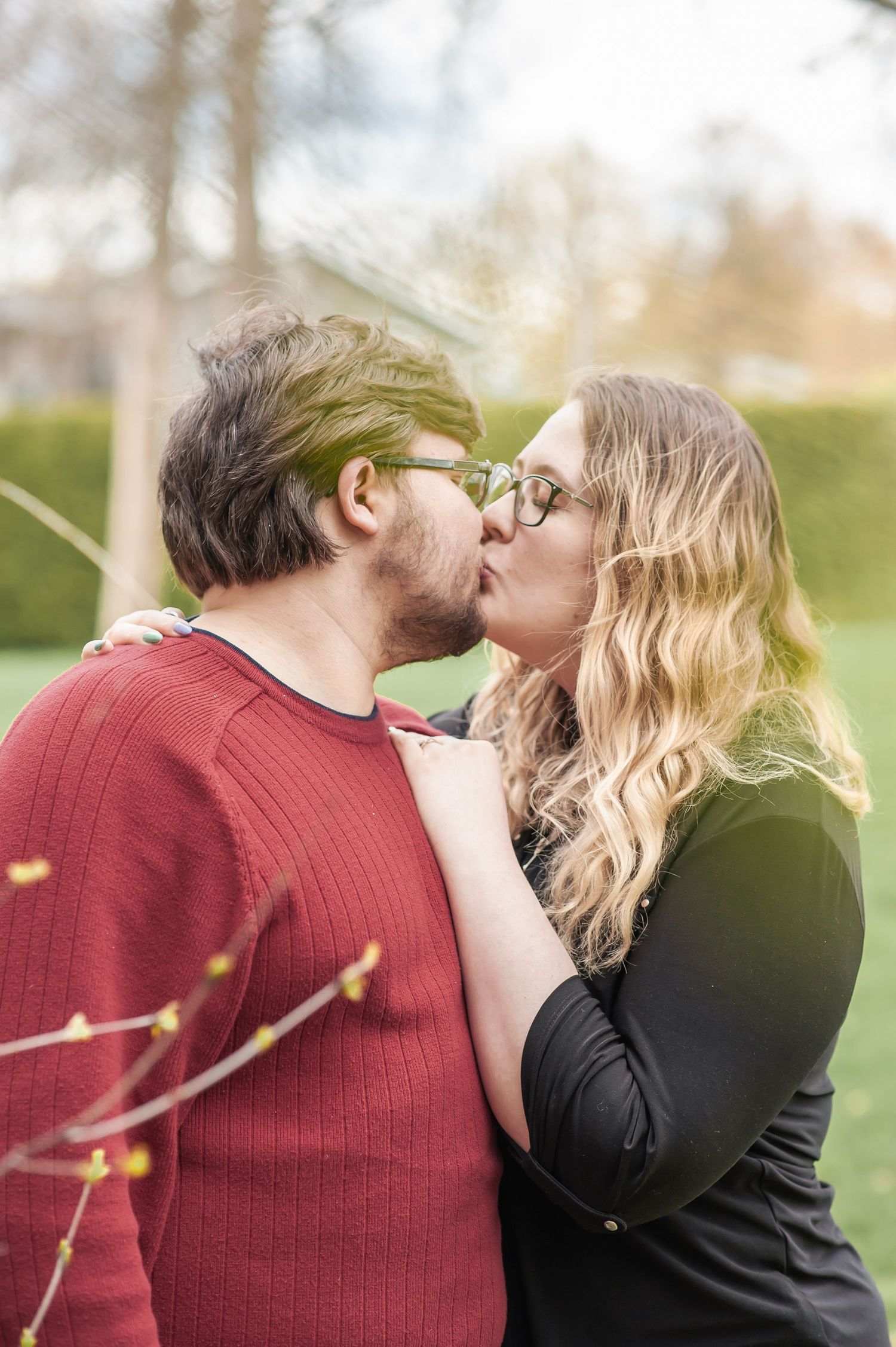 A romantic couple sharing a tender kiss outdoors in casual winter attire.