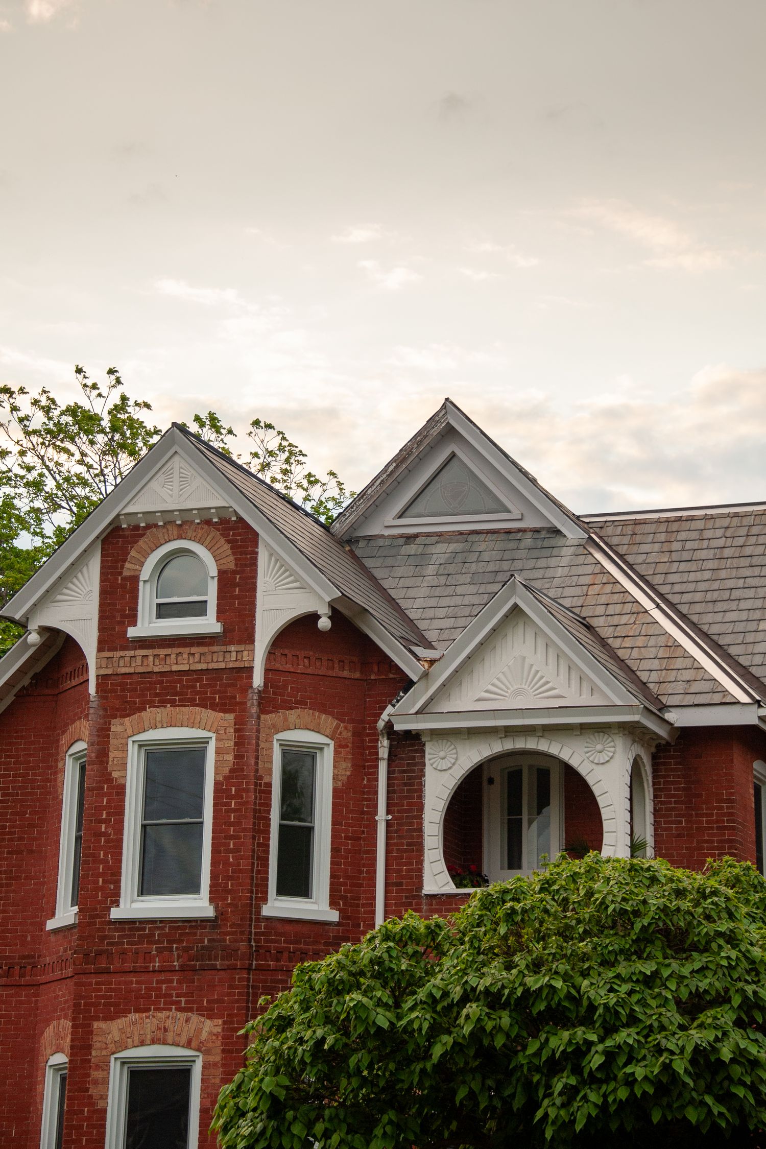 Historic Victorian red brick house with white trim and architectural details.