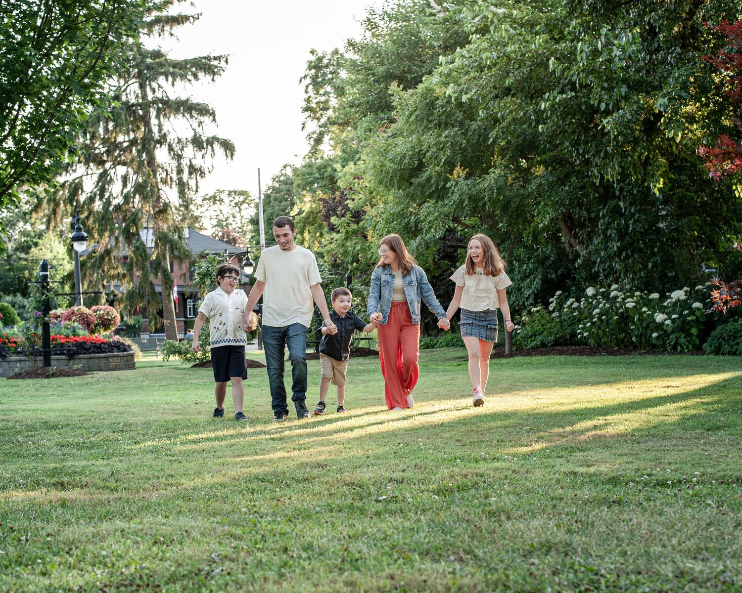 A group walks together on a grassy slope during golden hour sunset.