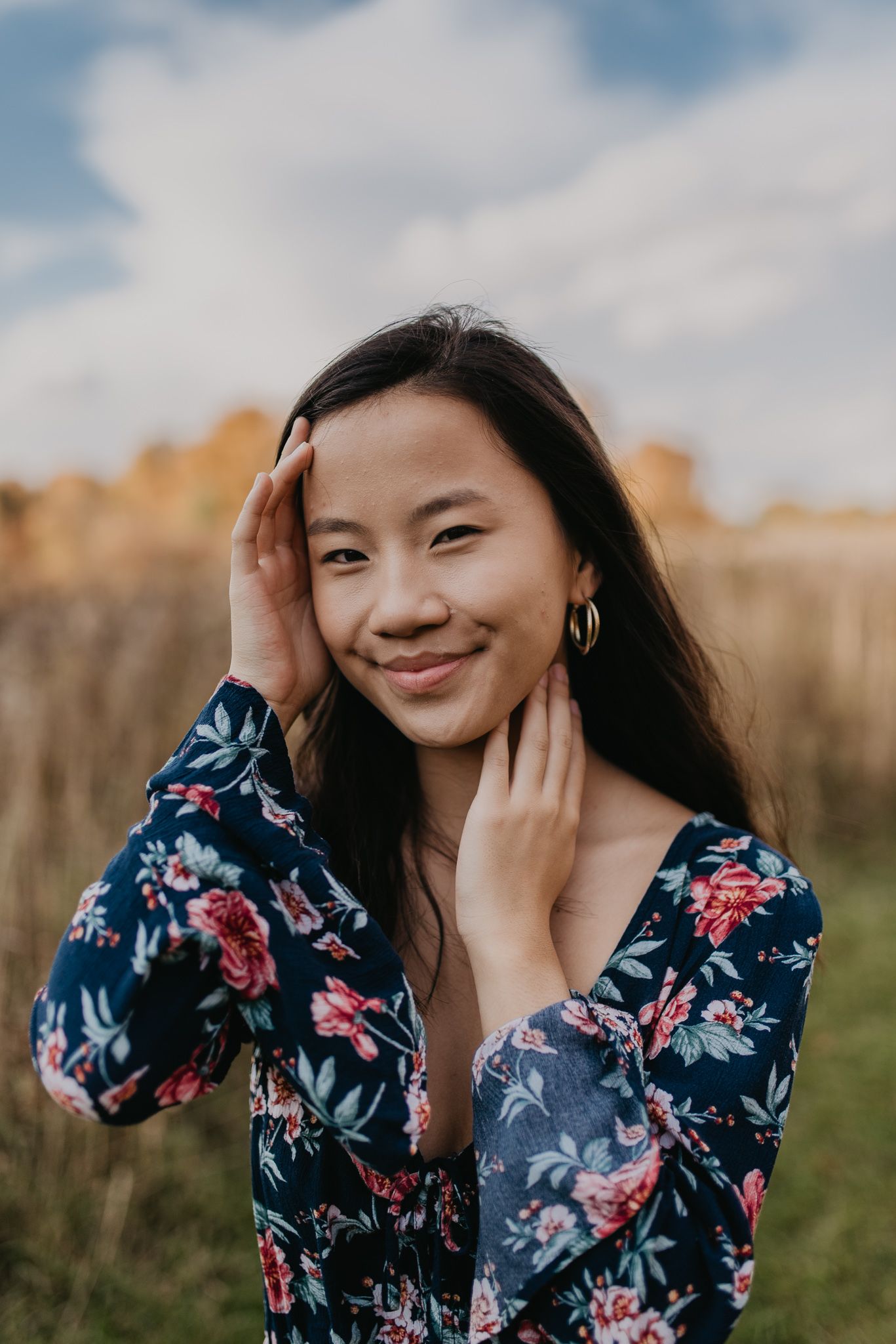 Close up portrait in floral dress against natural autumn backdrop.