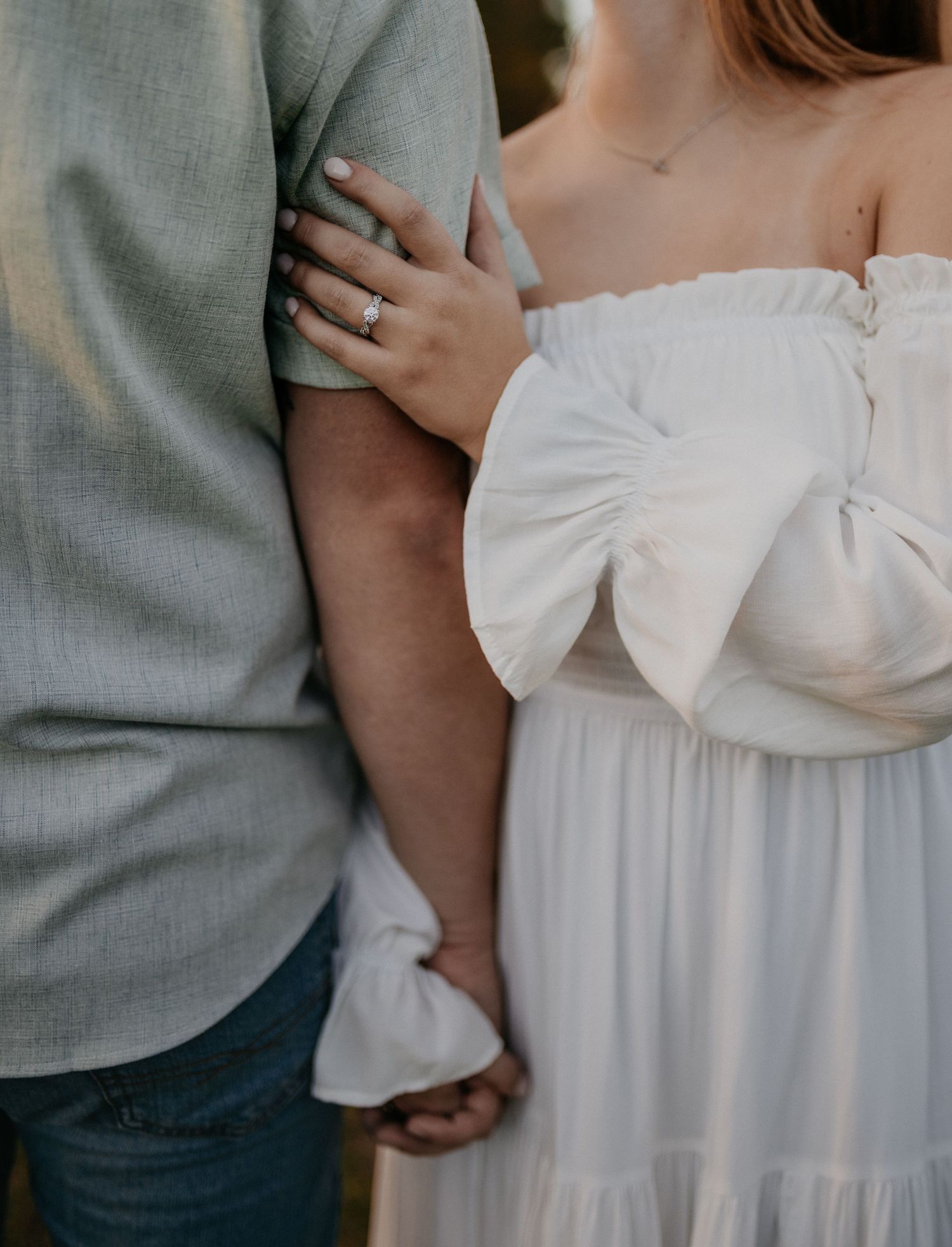 Close-up details of a white wedding dress with off-shoulder sleeves and romantic styling.