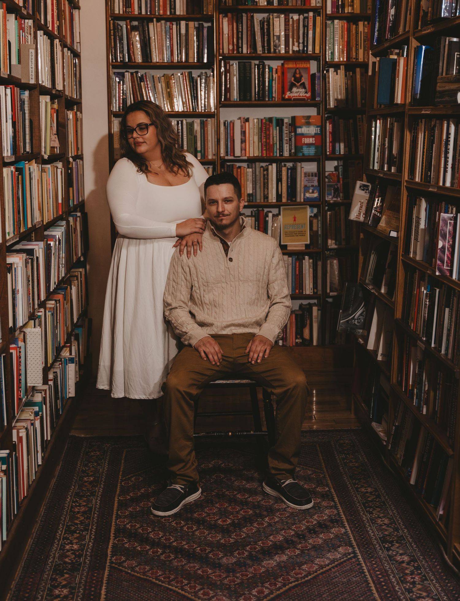 A series of photos showing people posing in a cozy library with floor-to-ceiling bookshelves and a patterned rug.