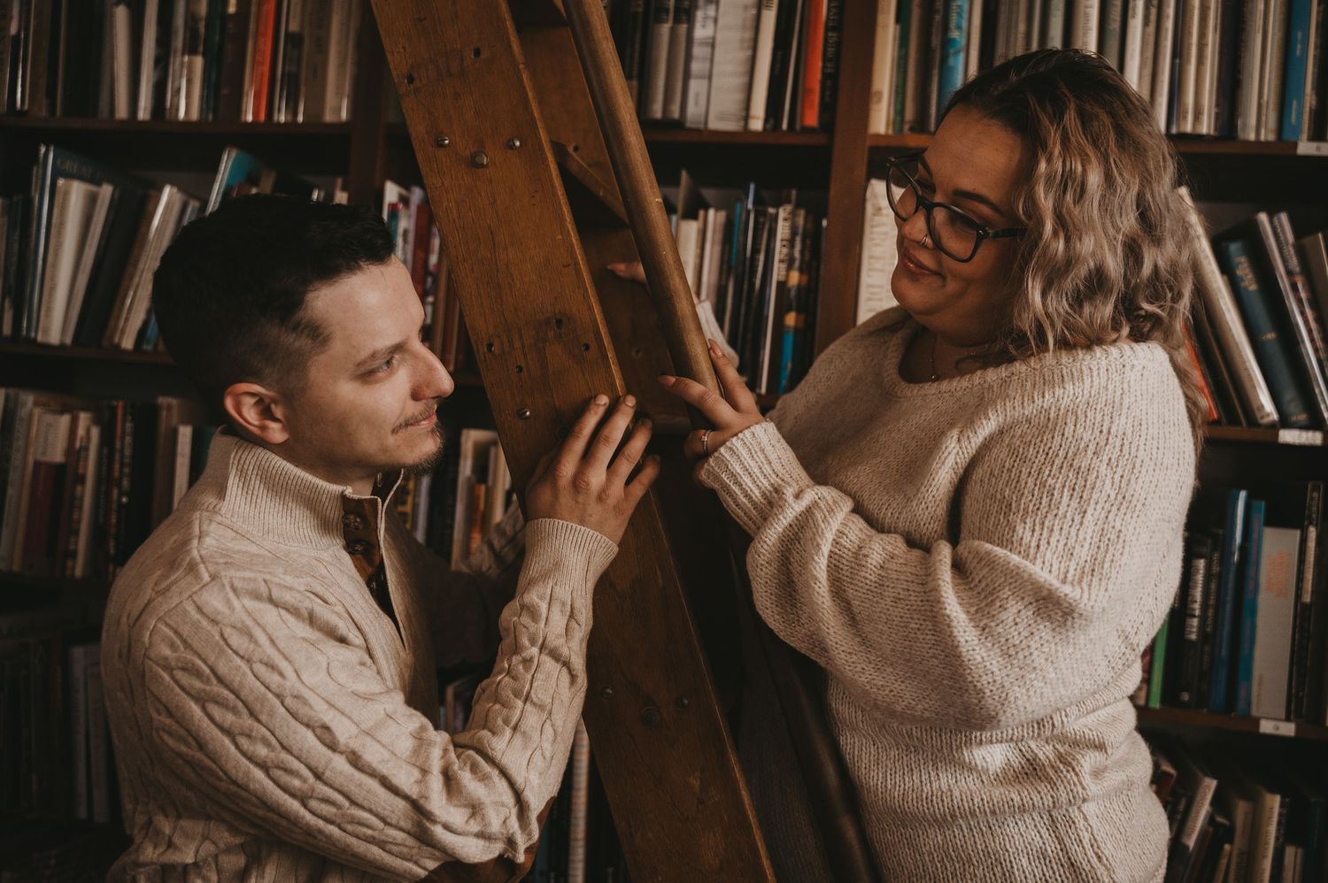 Intimate couple sharing tender moments against a backdrop of bookshelves in a cozy indoor setting.