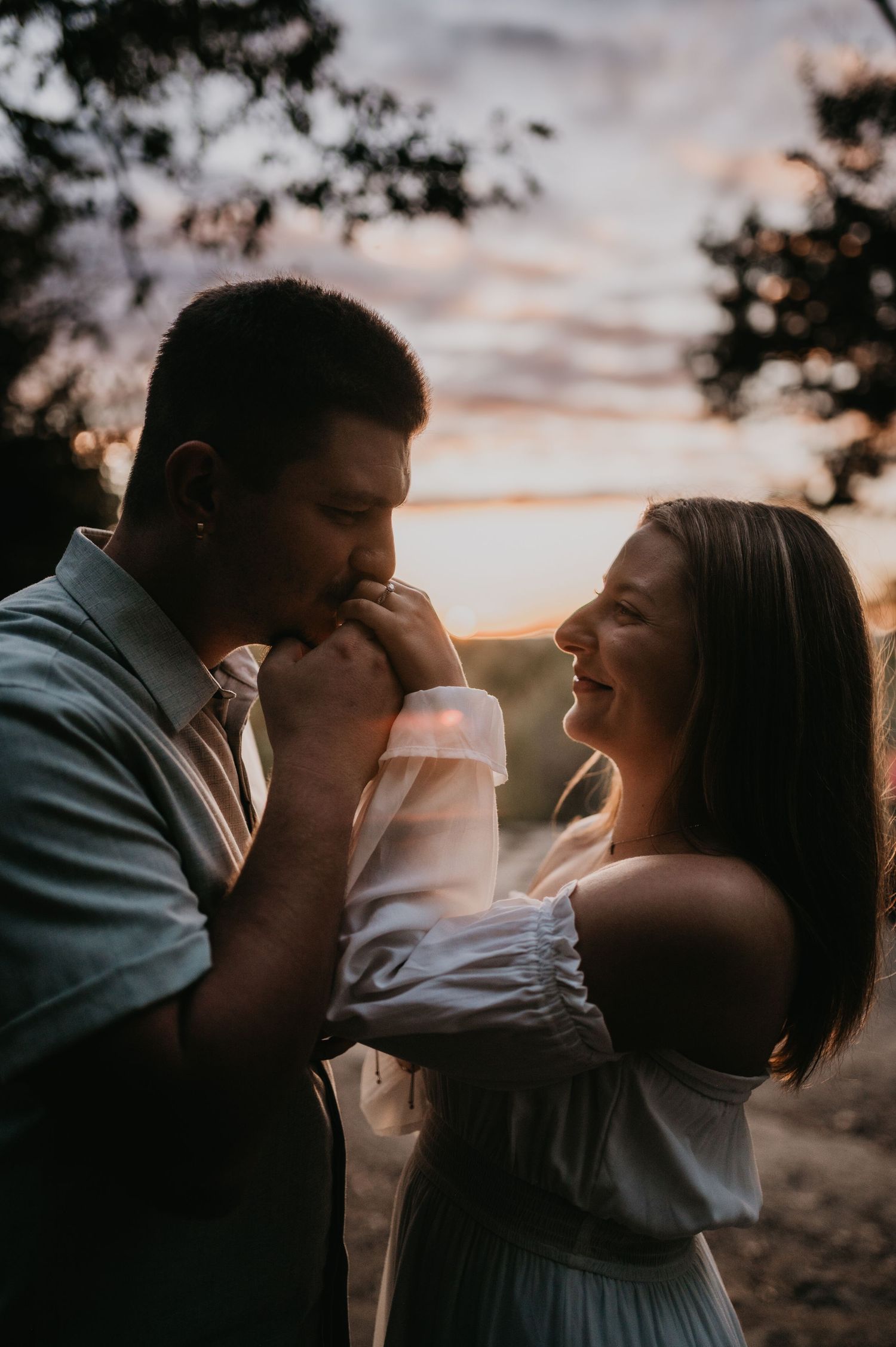 Intimate couple's portrait session at sunset with dramatic lighting and shadows.