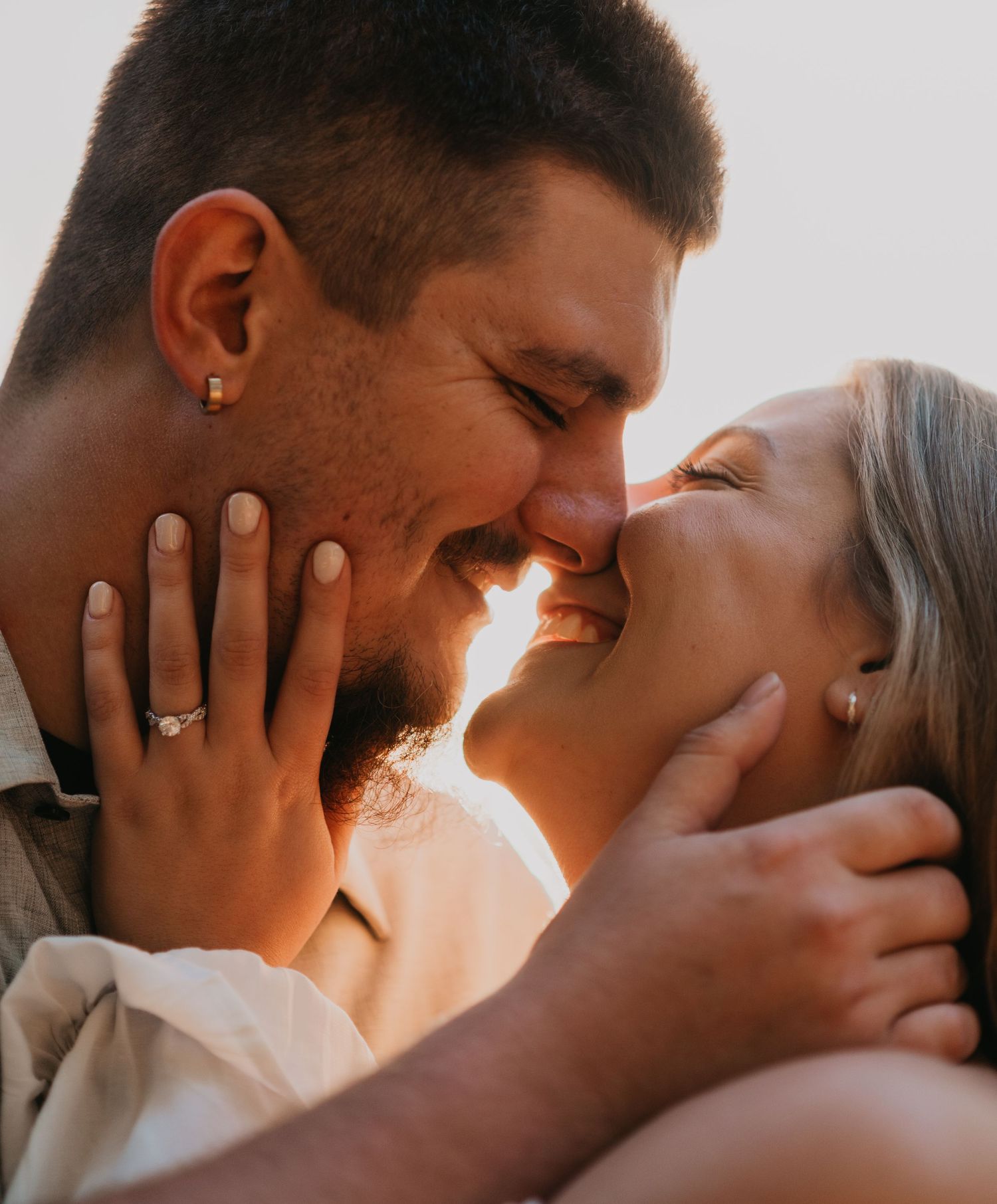 An intimate close-up portrait of a couple sharing a tender moment in soft lighting.