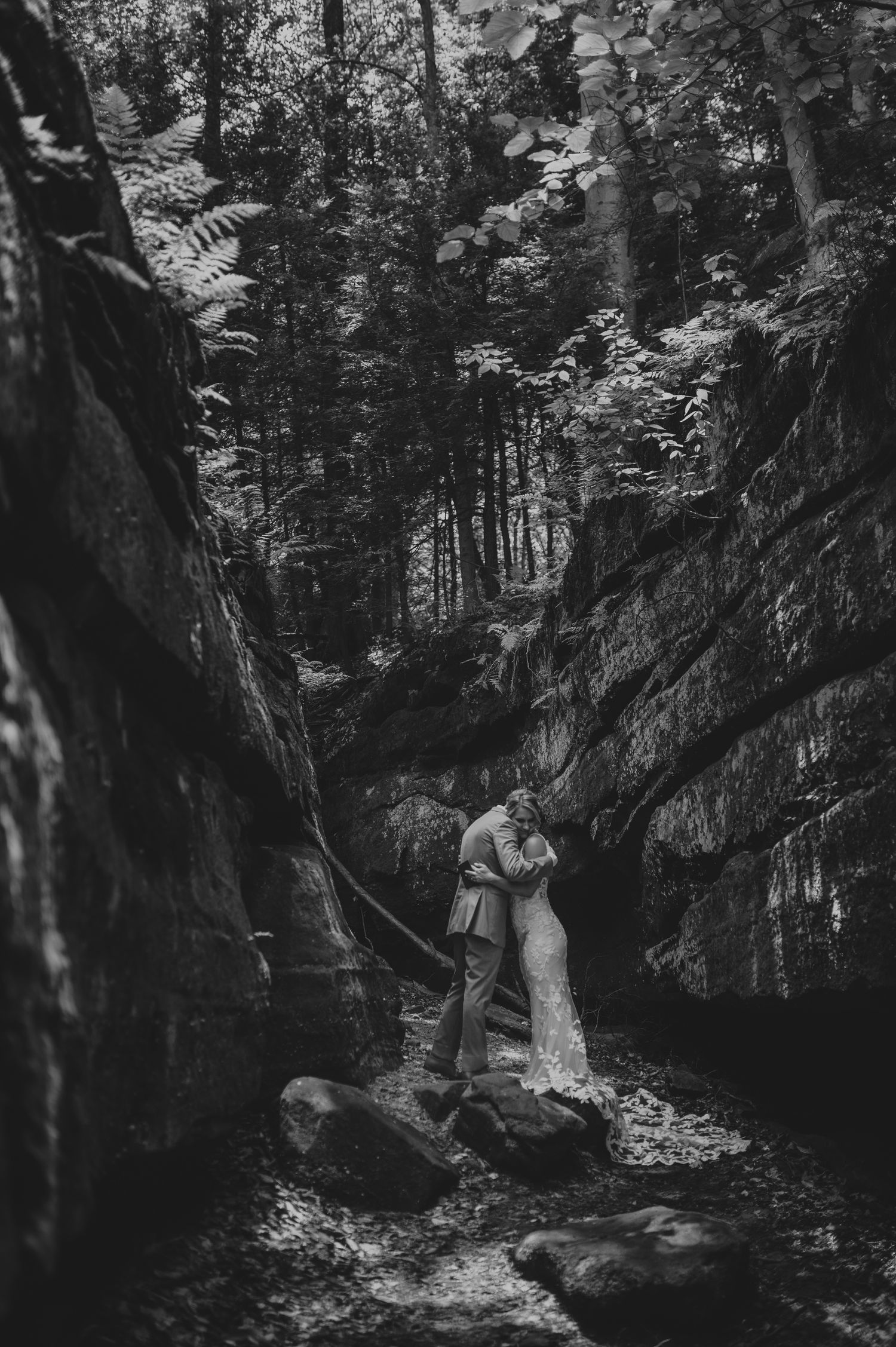 A black and white wedding photo series captured in a moody forest setting.