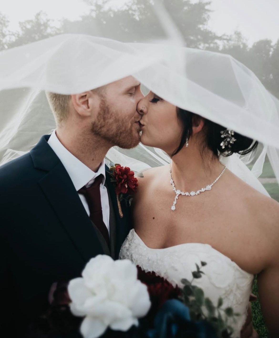 Elegant monochromatic wedding photos showing couple sharing intimate kisses with veil detail.