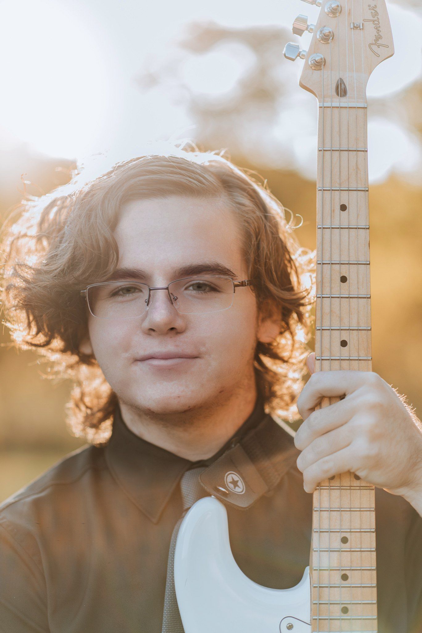 Three similar portraits in warm sunset lighting showing a person with curly hair posing with a guitar neck visible.