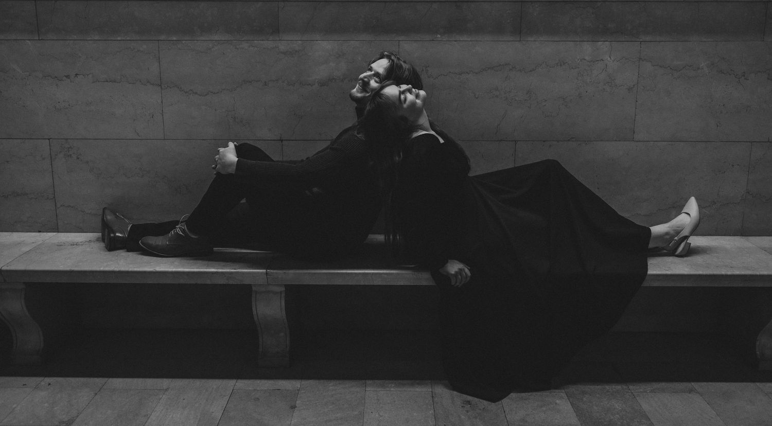 A black and white photo series shows a person lying down in different positions on a dark floor.