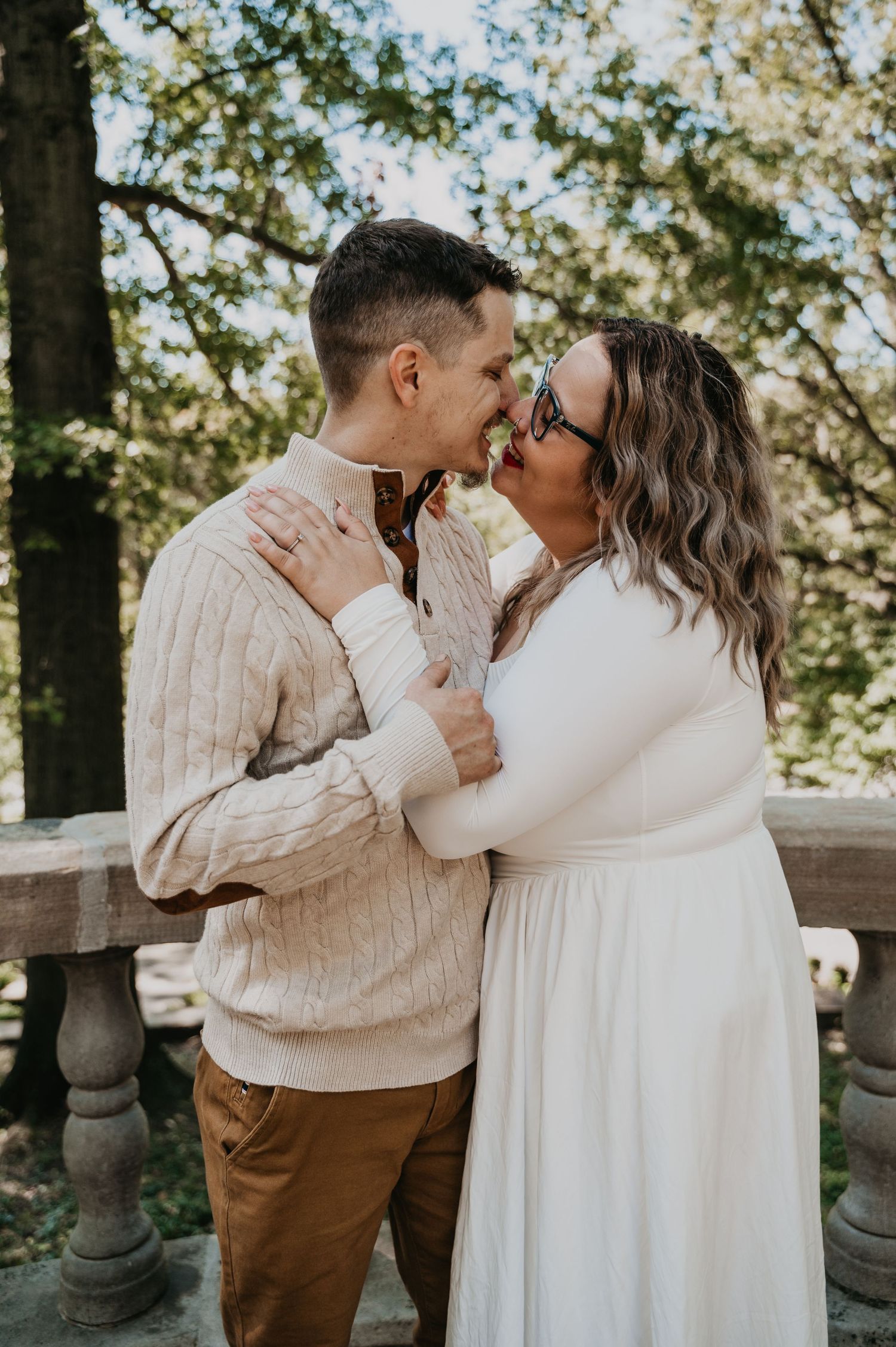 A couple shares intimate moments in a series of romantic outdoor photos wearing coordinated cream and brown outfits.