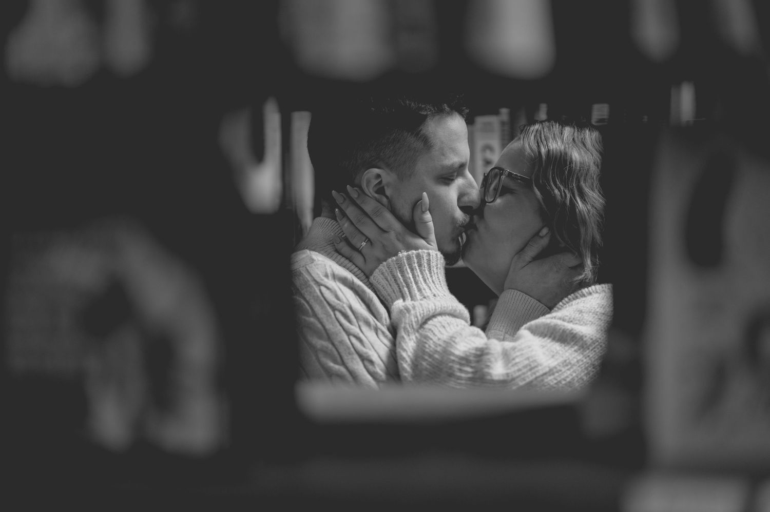A romantic black and white photograph capturing an intimate moment between two people in an embrace.