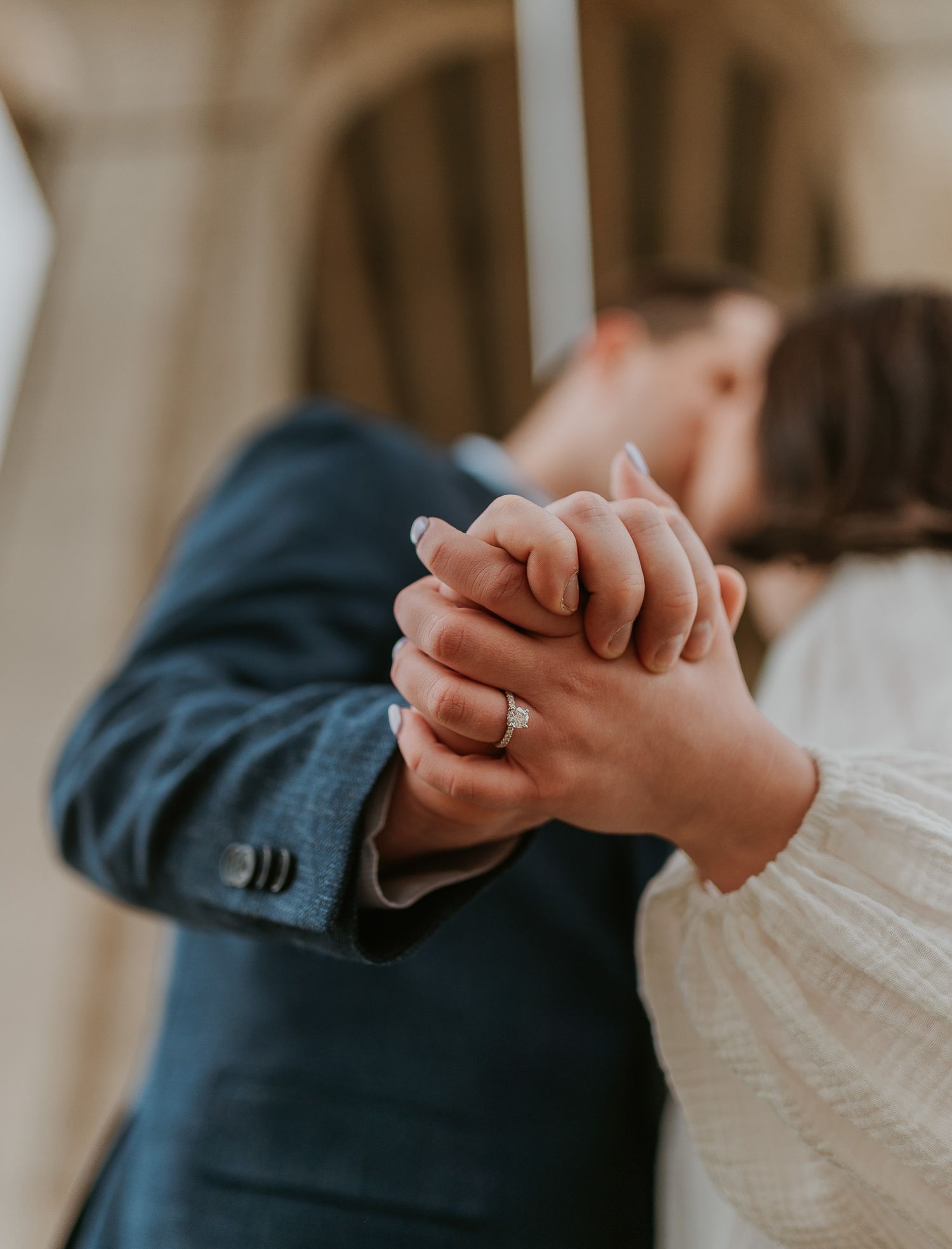 Close-up detail shots of hands holding and embracing during an engagement session.