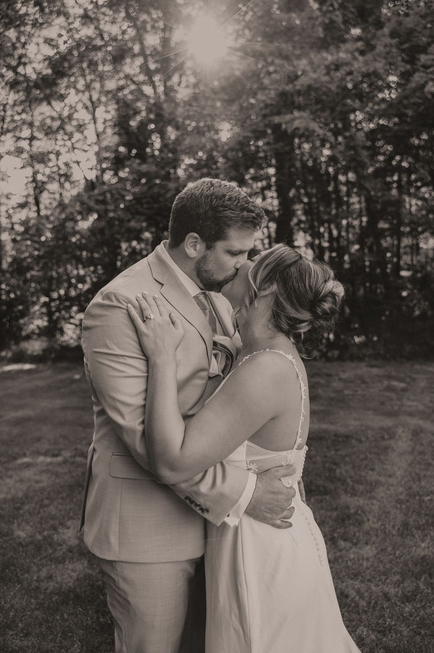 A romantic black and white photo captures an intimate moment between a couple in formal attire.