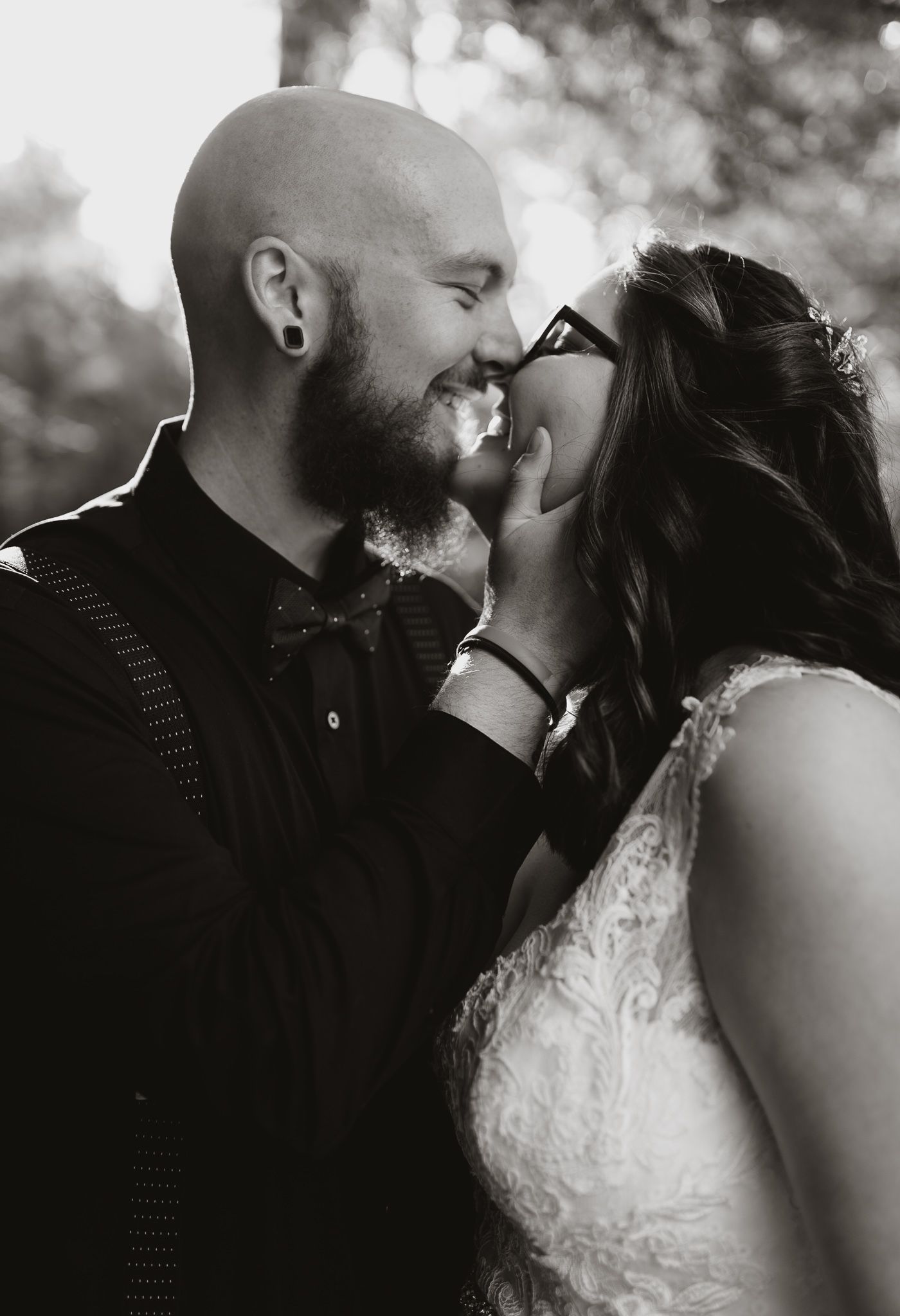Black and white intimate portrait of couple sharing a tender moment outdoors.