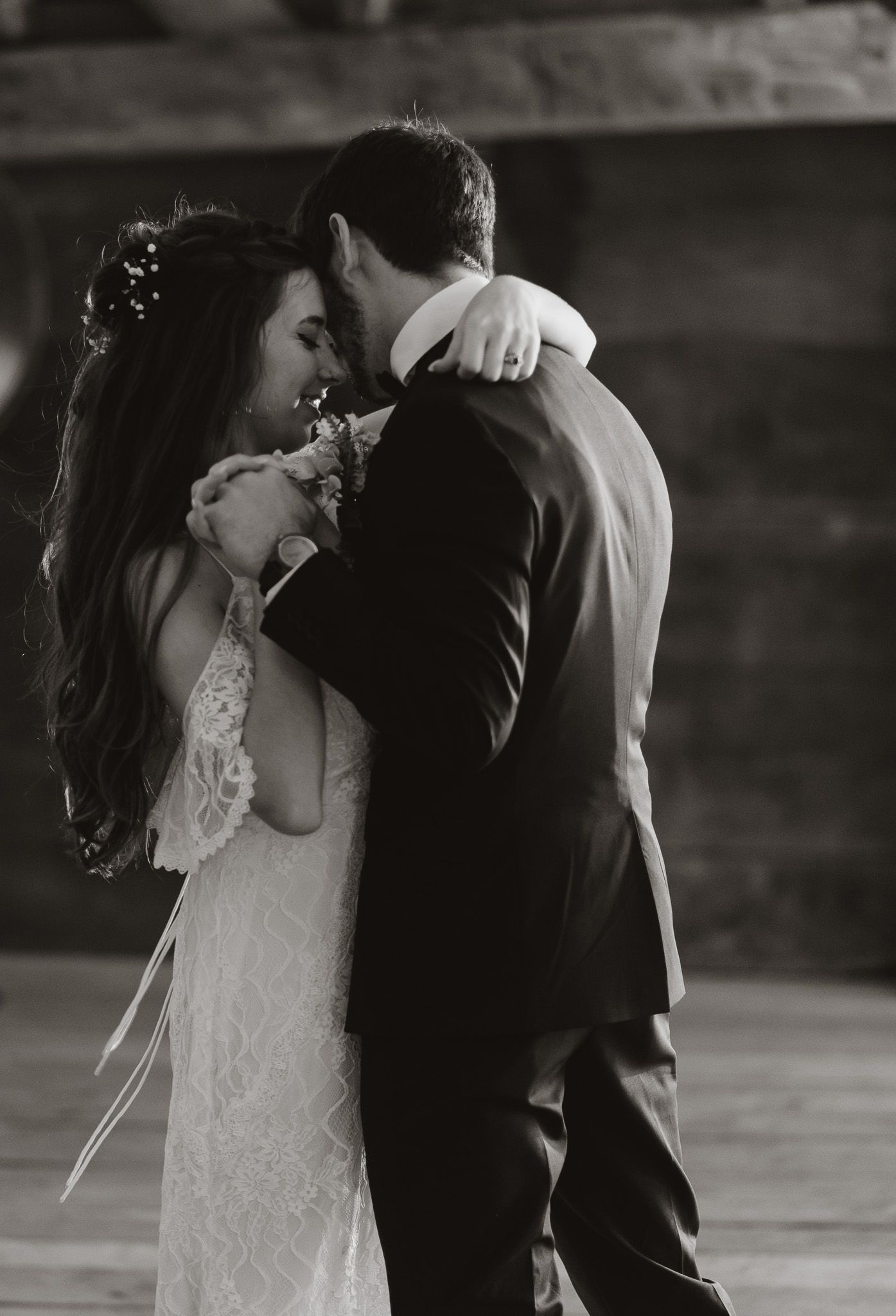 Intimate black and white portrait of newlyweds sharing their first kiss.