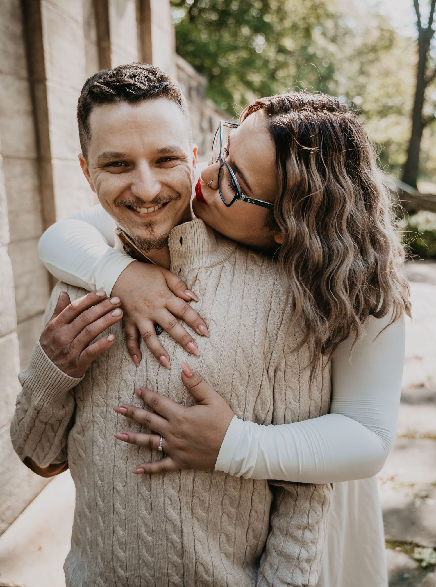 A couple shares tender embraces in a series of candid outdoor photos showing affection and laughter.