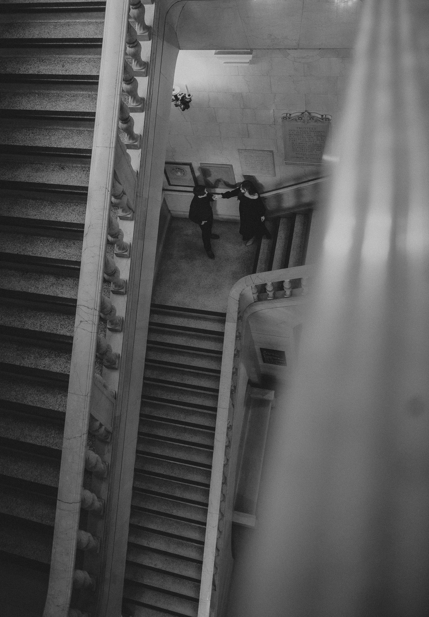 A series of black and white photographs showing a descending staircase with dramatic lighting and shadows.